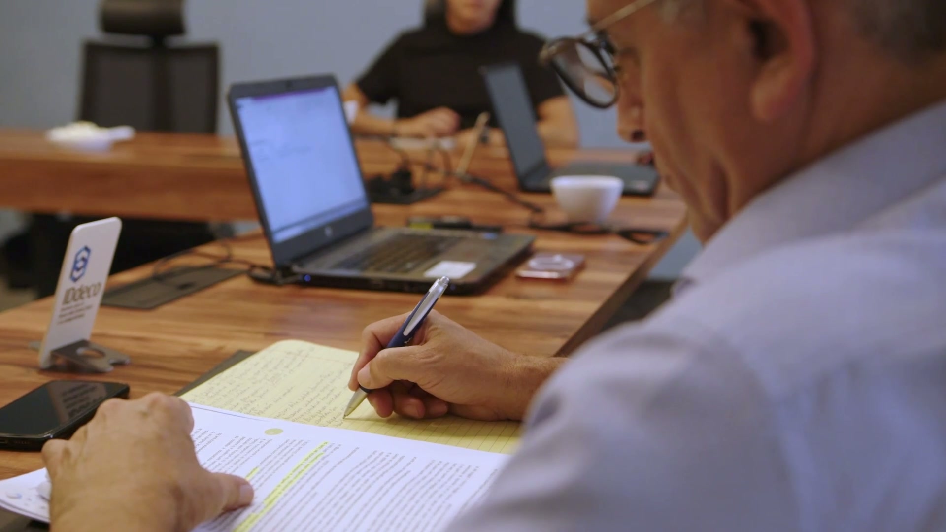 Equipo de IDDECO en un taller de trabajo colaborativo con documentos, laptops y la marca IDDECO sobre la mesa